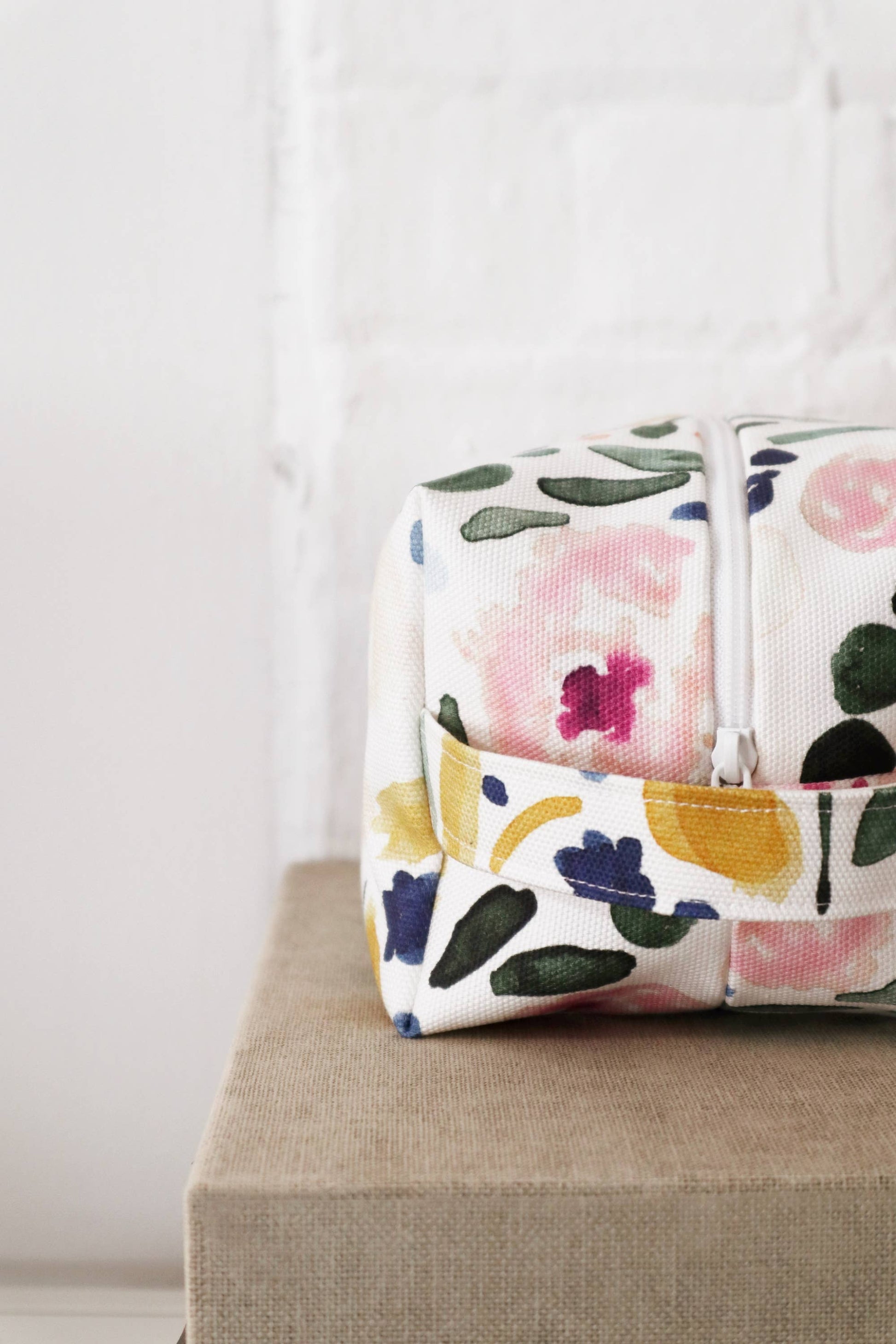 Gros plan sur trousse en coton bio fleuri avec fermeture éclair blanche