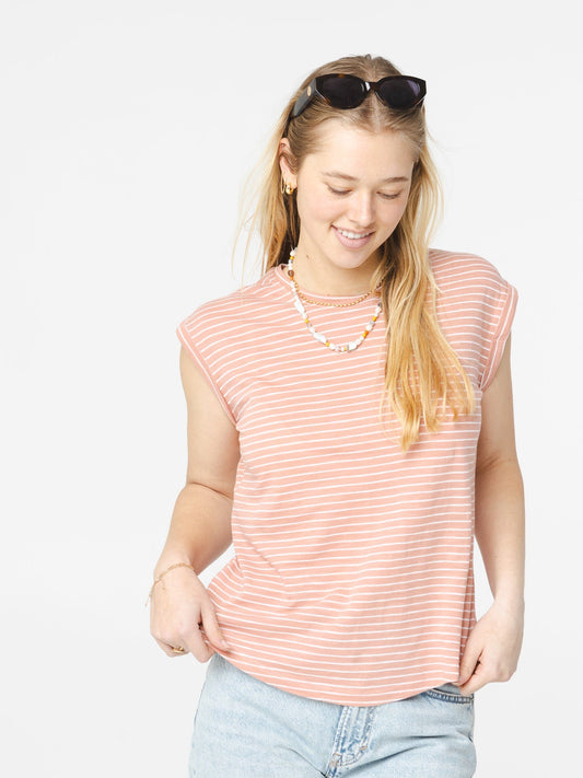 Femme portant un t-shirt marinière rose et blanc avec coupe décontractée
