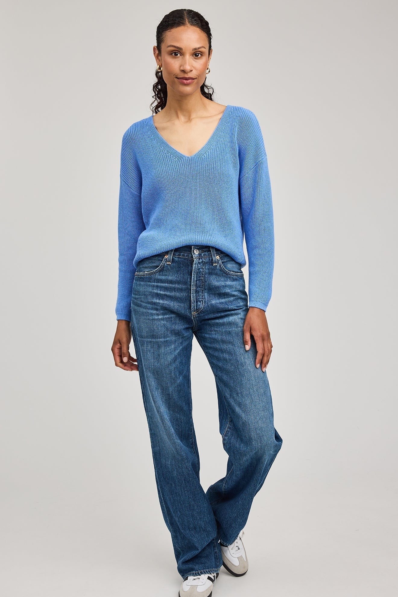 Vue complète du pull bleu pacifique coupe décontractée en point demi-cardigan porté avec un jean