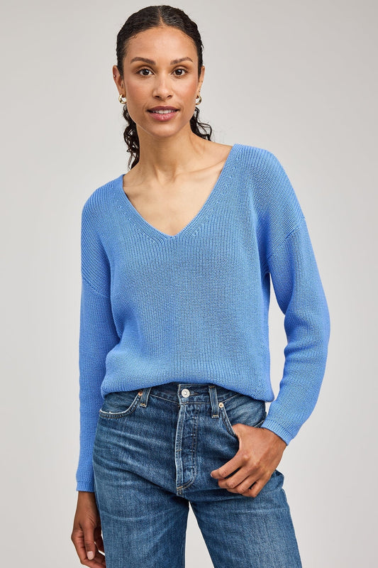 Gros plan sur l’encolure en V du pull bleu pacifique coupe décontractée en point demi-cardigan