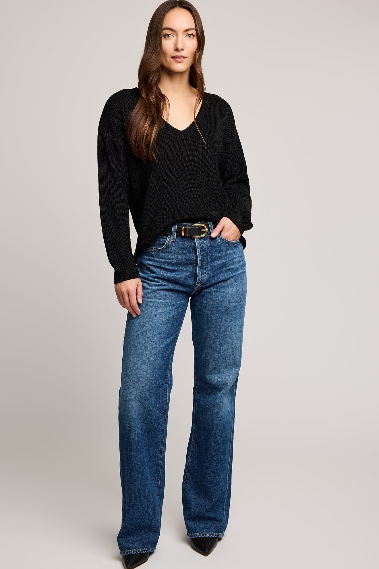 Vue complète du pull noir coupe décontractée en point demi-cardigan porté avec un jean