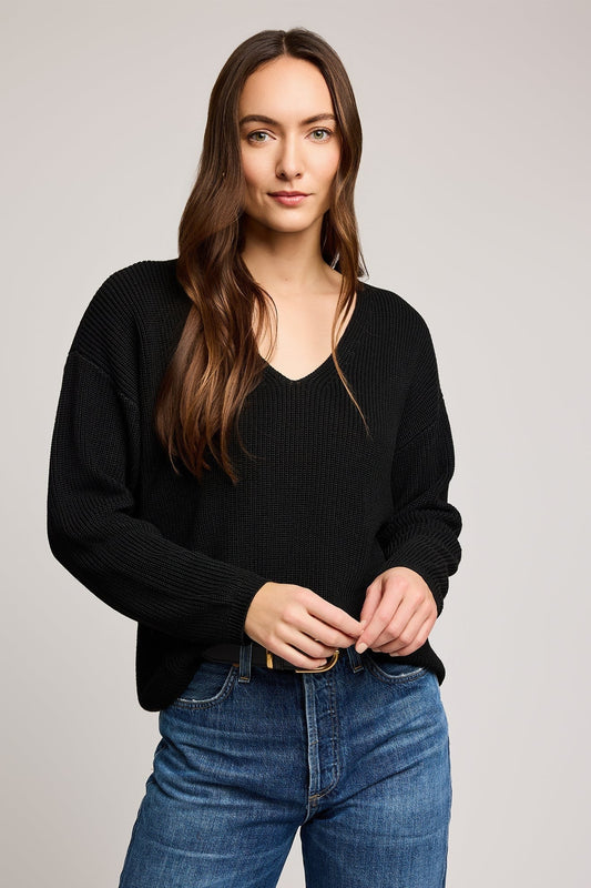 Gros plan sur l’encolure en V du pull noir coupe décontractée en point demi-cardigan