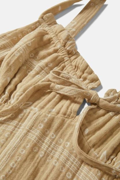 Gros plan sur l’encolure froncée et les liens à nouer de la robe beige 100 % coton