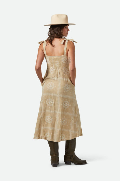 Vue de dos de la robe beige montrant le dos smocké et les bretelles nouées