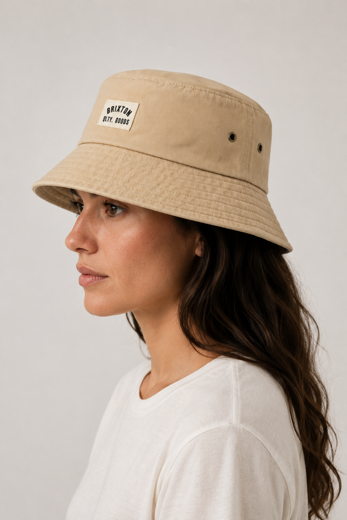 Femme portant le chapeau bob Woodburn beige de profil, avec œillets d’aération, bord court et finition vintage.