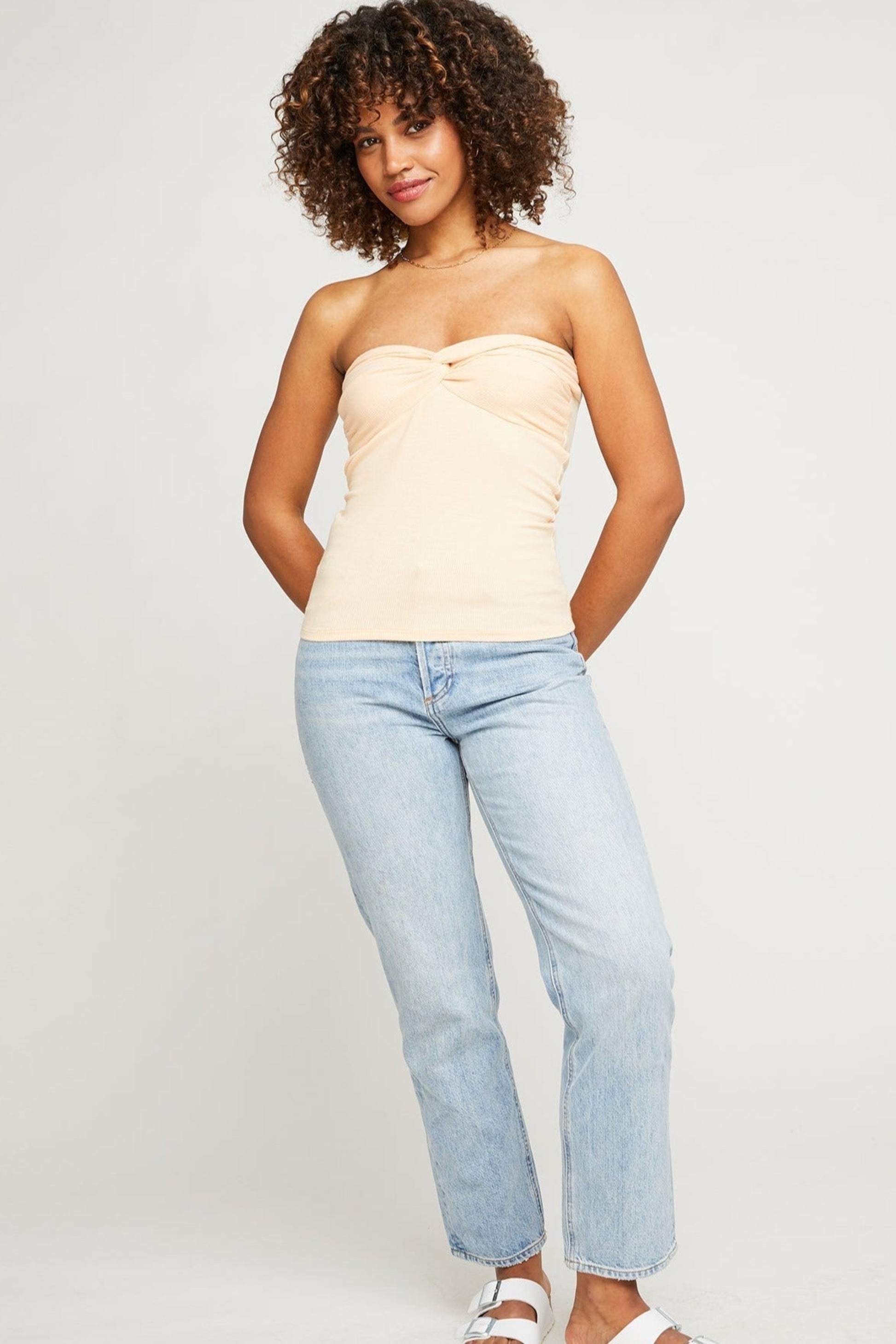 Bustier pêche porté avec un jean clair, coupe ajustée et tissu doux extensible.