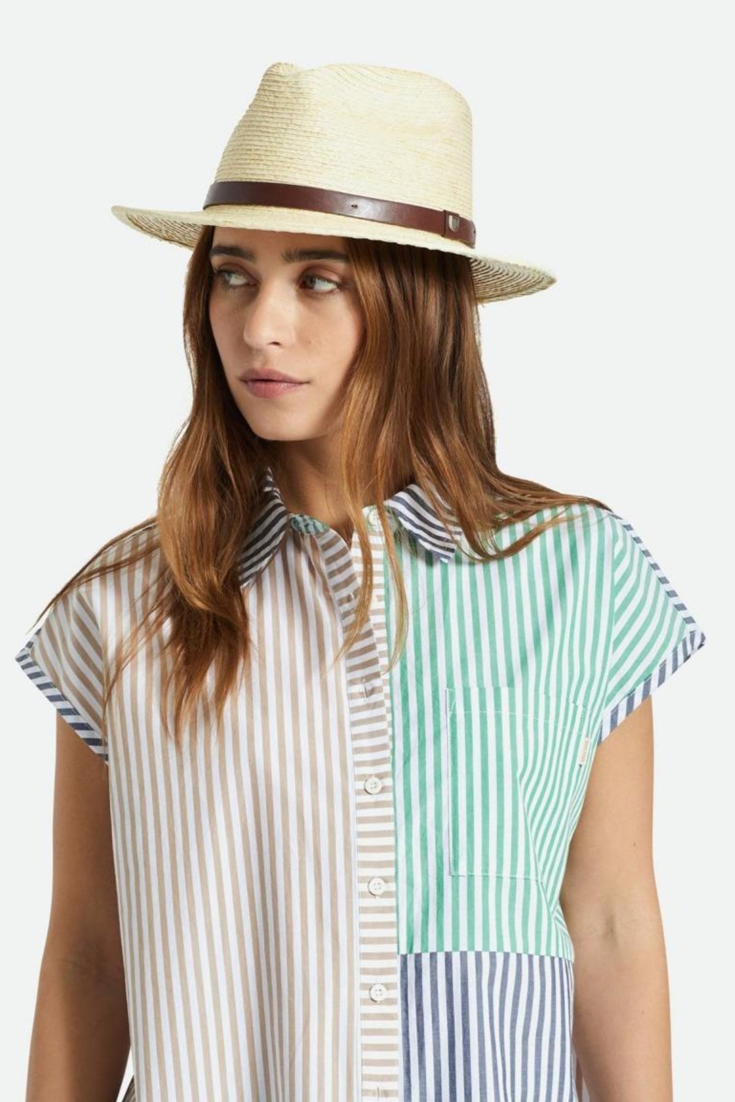 Femme portant le chapeau Messer paille avec bracelet en cuir brun, bord plat et style estival intemporel.